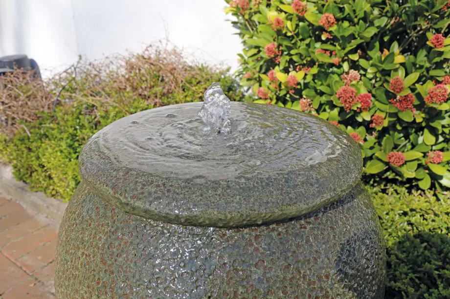 Palermo Keramik-Springbrunnen mit Schale in antiker Krugform, Wasser fließt in die Schale, aufgestellt auf einer Terrasse mit roten Pflastersteinen.