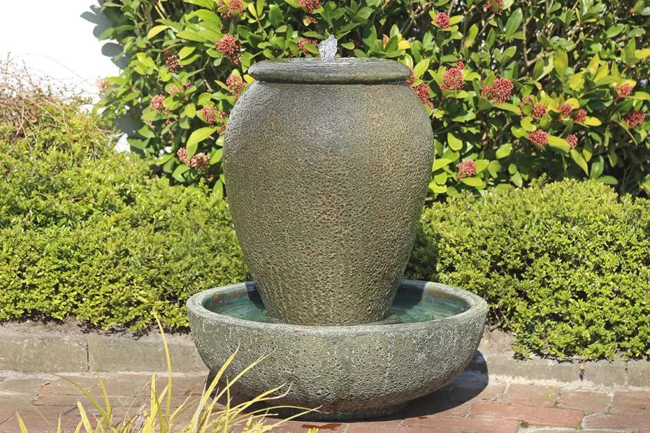 Palermo Keramik-Springbrunnen mit Schale in antiker Krugform, Wasser fließt in die Schale, aufgestellt auf einer Terrasse mit roten Pflastersteinen.