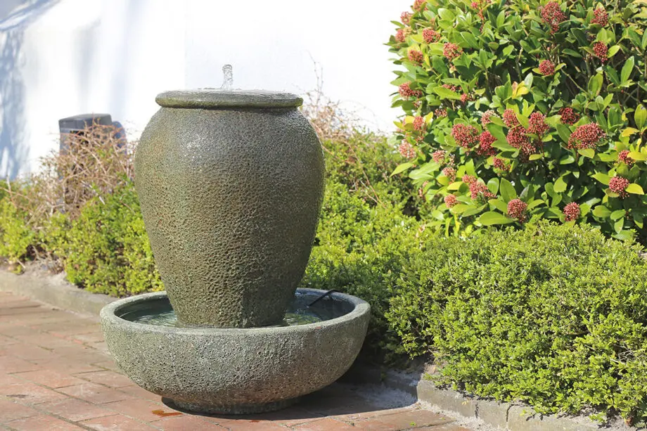 Palermo Keramik-Springbrunnen mit Schale in antiker Krugform, Wasser fließt in die Schale, aufgestellt auf einer Terrasse mit roten Pflastersteinen.