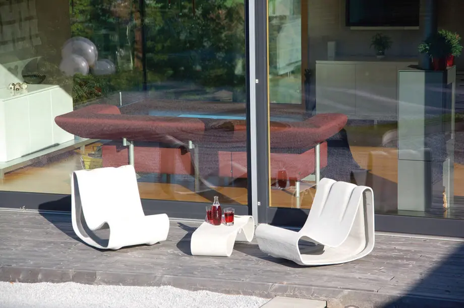 Guhl Sessel (Loop Chair) aus Faserzement in einem modernen Garten, umgeben von Gräsern und minimalistischer Landschaftsgestaltung.